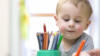 Child playing with colouring pencils