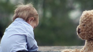 baby and teddy bear on a bridge