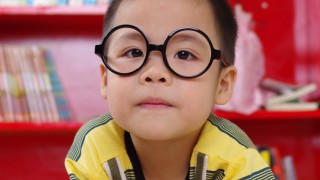 child wearing glasses reading book