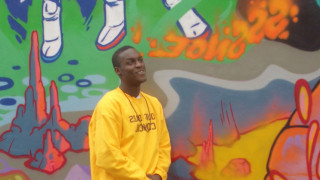 YDC dad stands in front of graffiti wall art