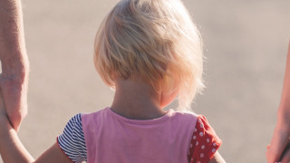 child holding hands with two adults