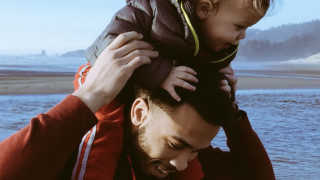 child on dads shoulders, beach