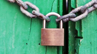 A locked chain on a green door