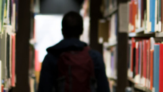 School boy in a library aisle